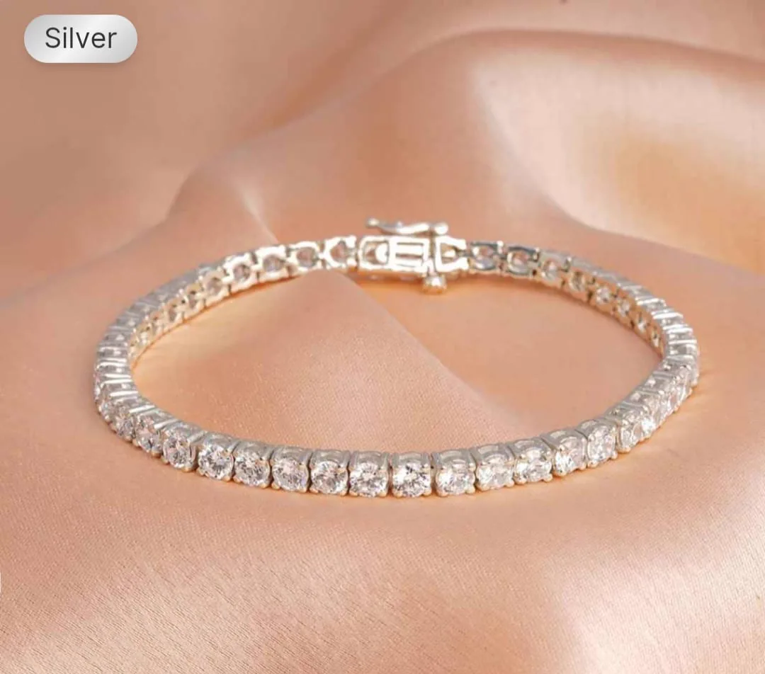 The seller's own flat listing photo of a silver cubic-zirconia tennis bracelet on peach silk, before Nitaris